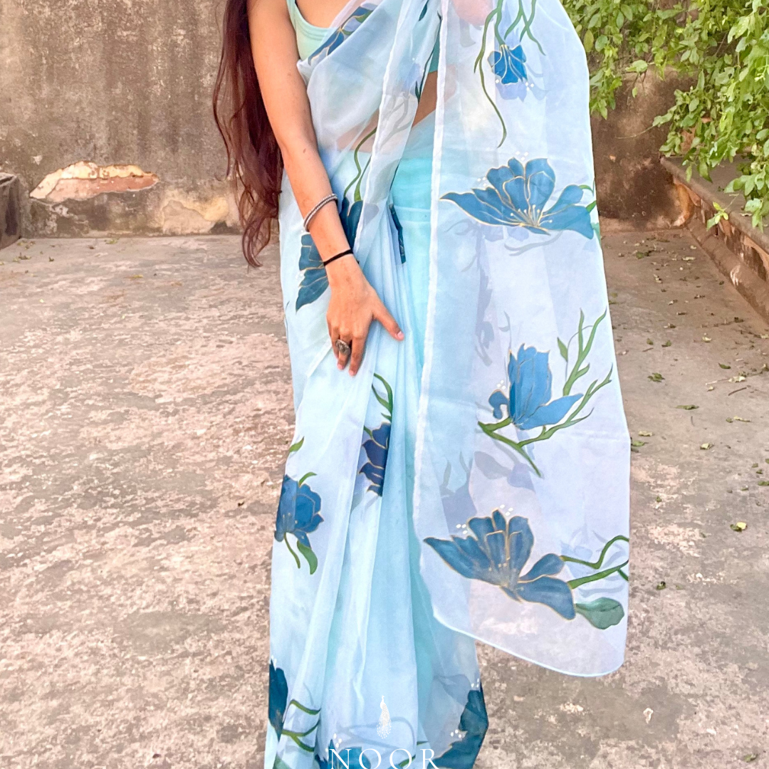 hand painted saree in pure organza silk by noor by hansa in teal colour paired with a pure cotton blouse piece, shells on the pallu