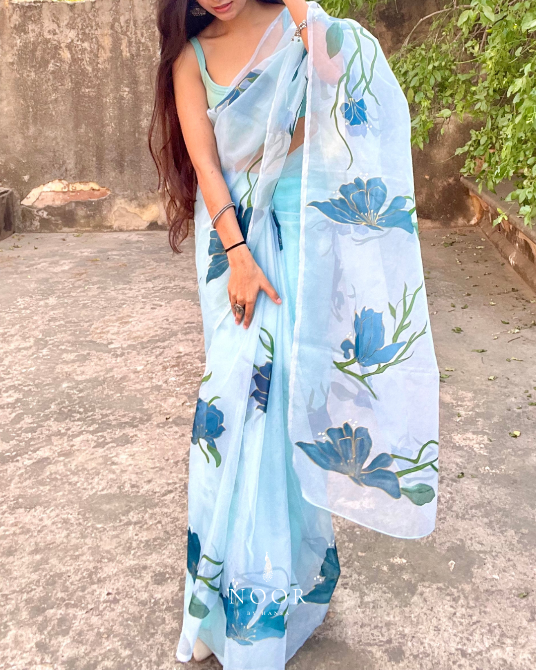 hand painted saree in pure organza silk by noor by hansa in teal colour paired with a pure cotton blouse piece, shells on the pallu