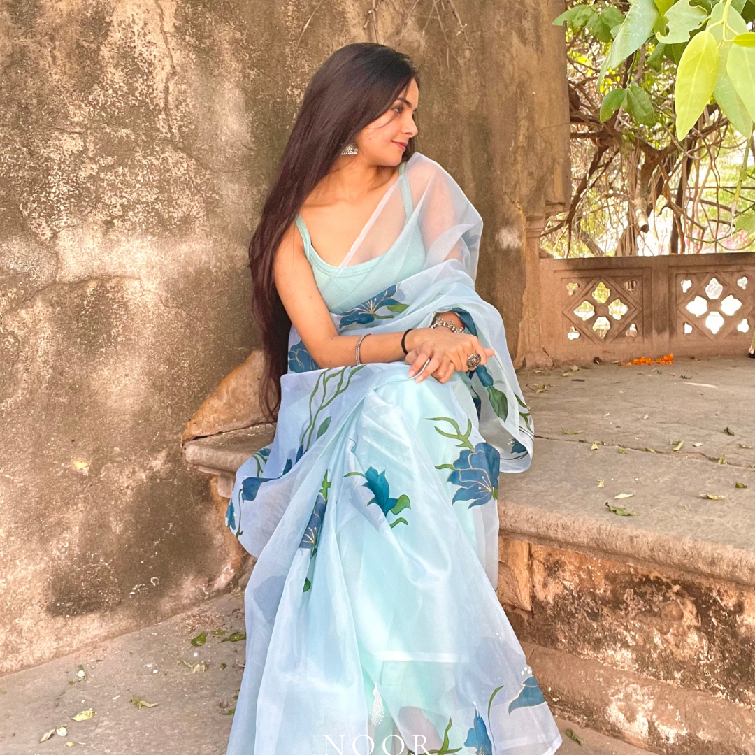 hand painted saree in pure organza silk by noor by hansa in teal colour paired with a pure cotton blouse piece, shells on the pallu