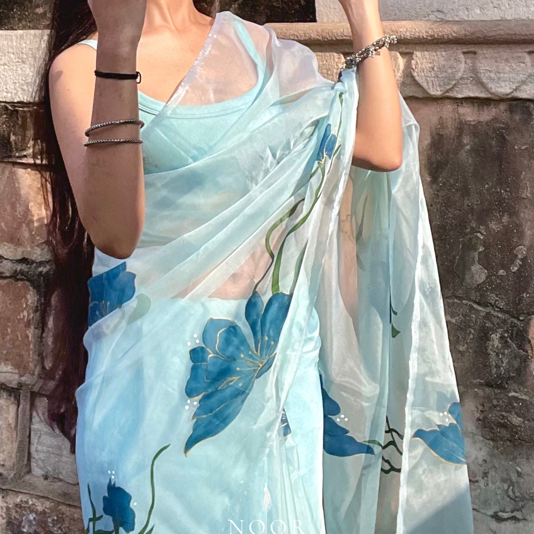 hand painted saree in pure organza silk by noor by hansa in teal colour paired with a pure cotton blouse piece, shells on the pallu