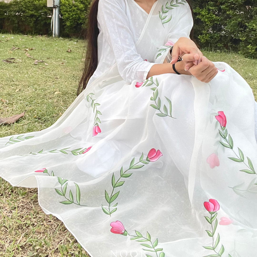 hand painted ivory 'jaituni' odhani in pure organza silk fabric with hand-painted motifs of leaves & pink tulips spread all over, embellished with studded stones. light and flowy, this makes for a perfect summer essential