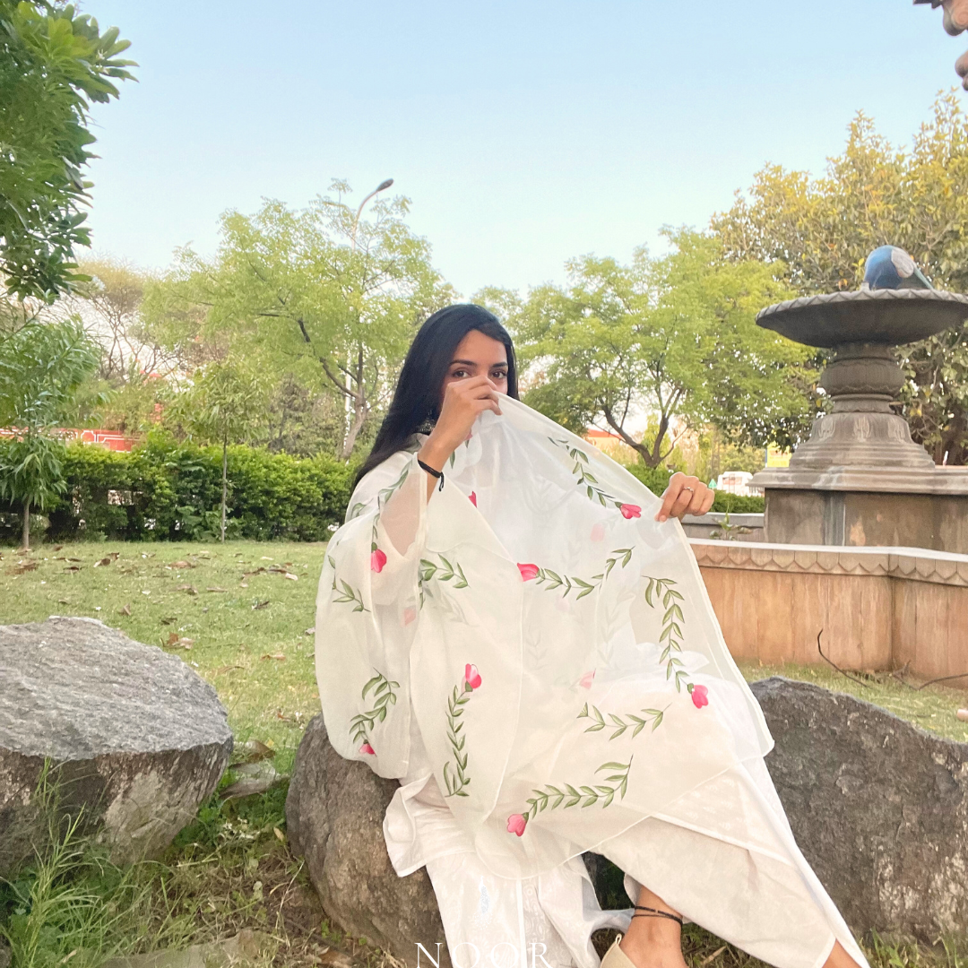 hand painted ivory 'jaituni' odhani in pure organza silk fabric with hand-painted motifs of leaves & pink tulips spread all over, embellished with studded stones. light and flowy, this makes for a perfect summer essential