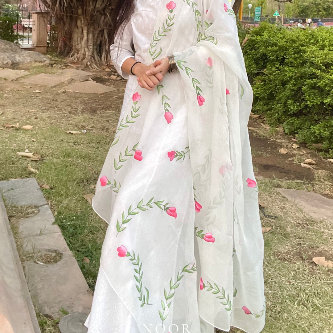 hand painted ivory 'jaituni' odhani in pure organza silk fabric with hand-painted motifs of leaves & pink tulips spread all over, embellished with studded stones. light and flowy, this makes for a perfect summer essential