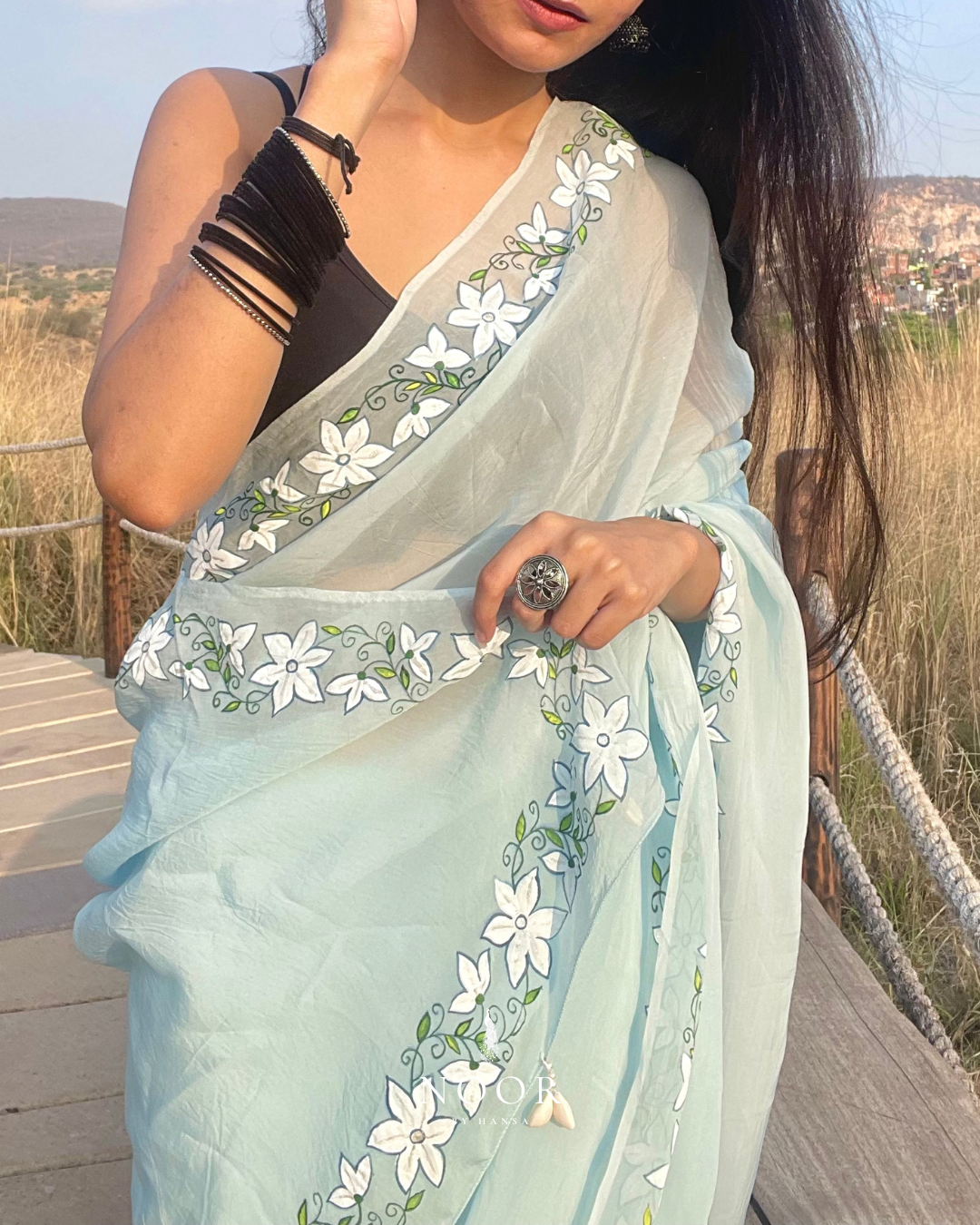 hand painted saree in pure organza silk by noor by hansa in blue colour paired with a pure cotton blouse piece, shells on the pallu