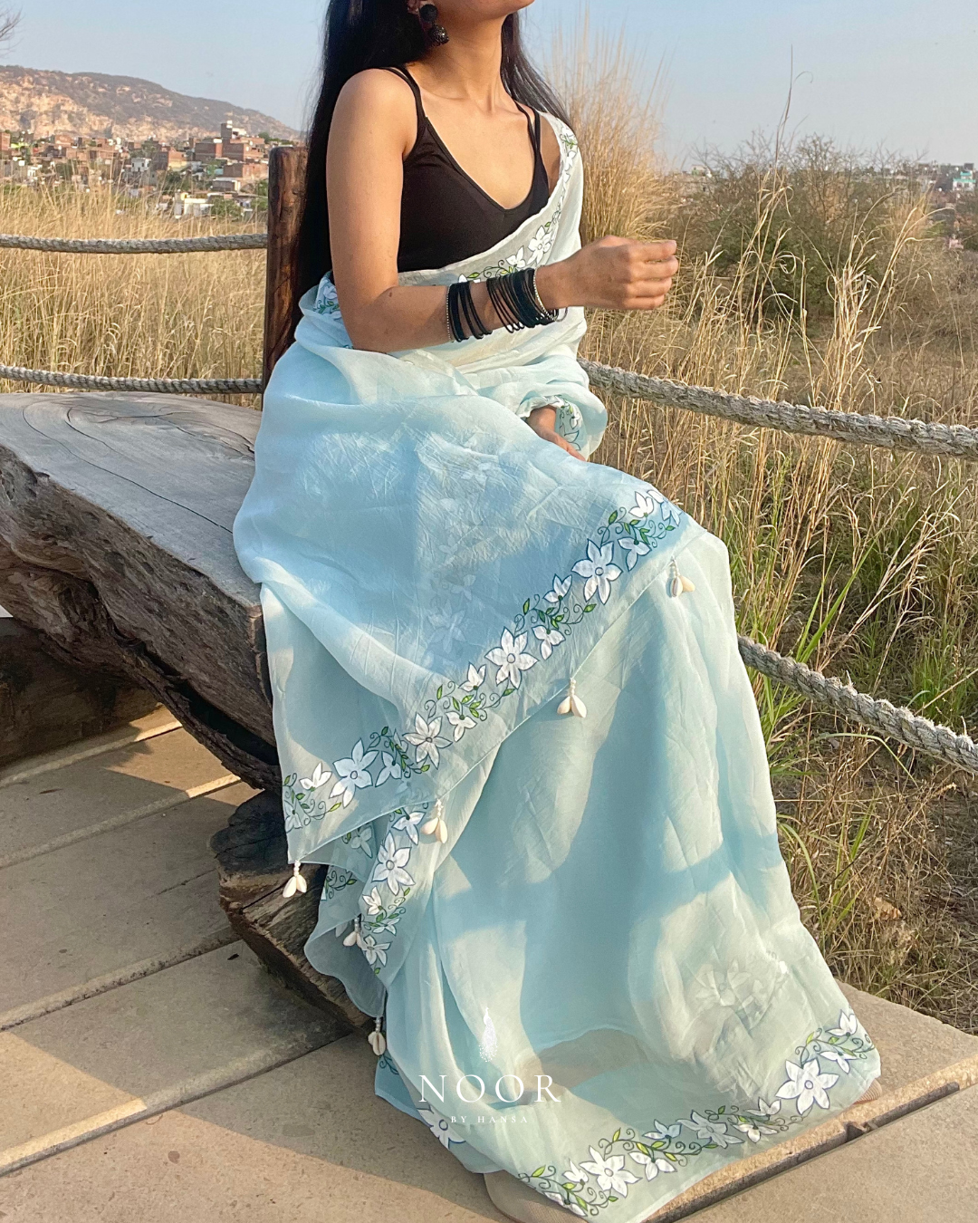 hand painted saree in pure organza silk by noor by hansa in blue colour paired with a pure cotton blouse piece, shells on the pallu