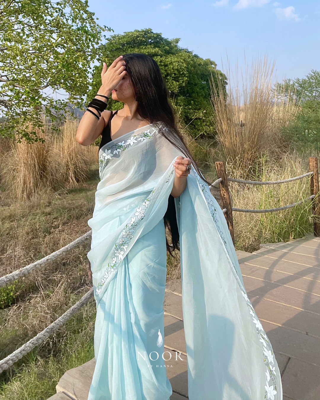 hand painted saree in pure organza silk by noor by hansa in blue colour paired with a pure cotton blouse piece, shells on the pallu