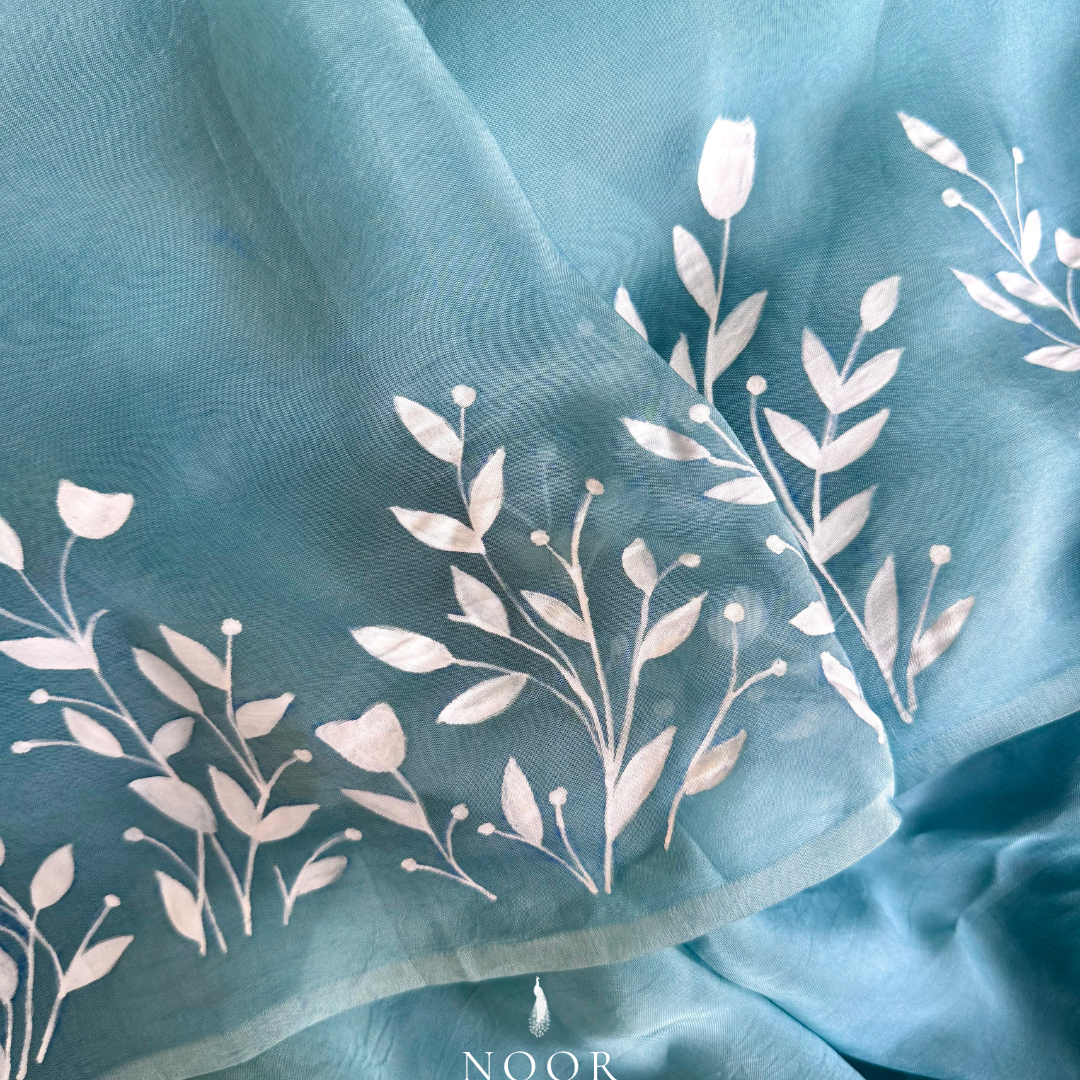 Teal blue sarees with white floral hand painted detailing.hand painted sarees
handpainted sarees
handpainted sari
hand painted saris
jaipur sarees
handcrafted saris
organza silk sarees
tissue sarees
tissue saris
organza silk saris