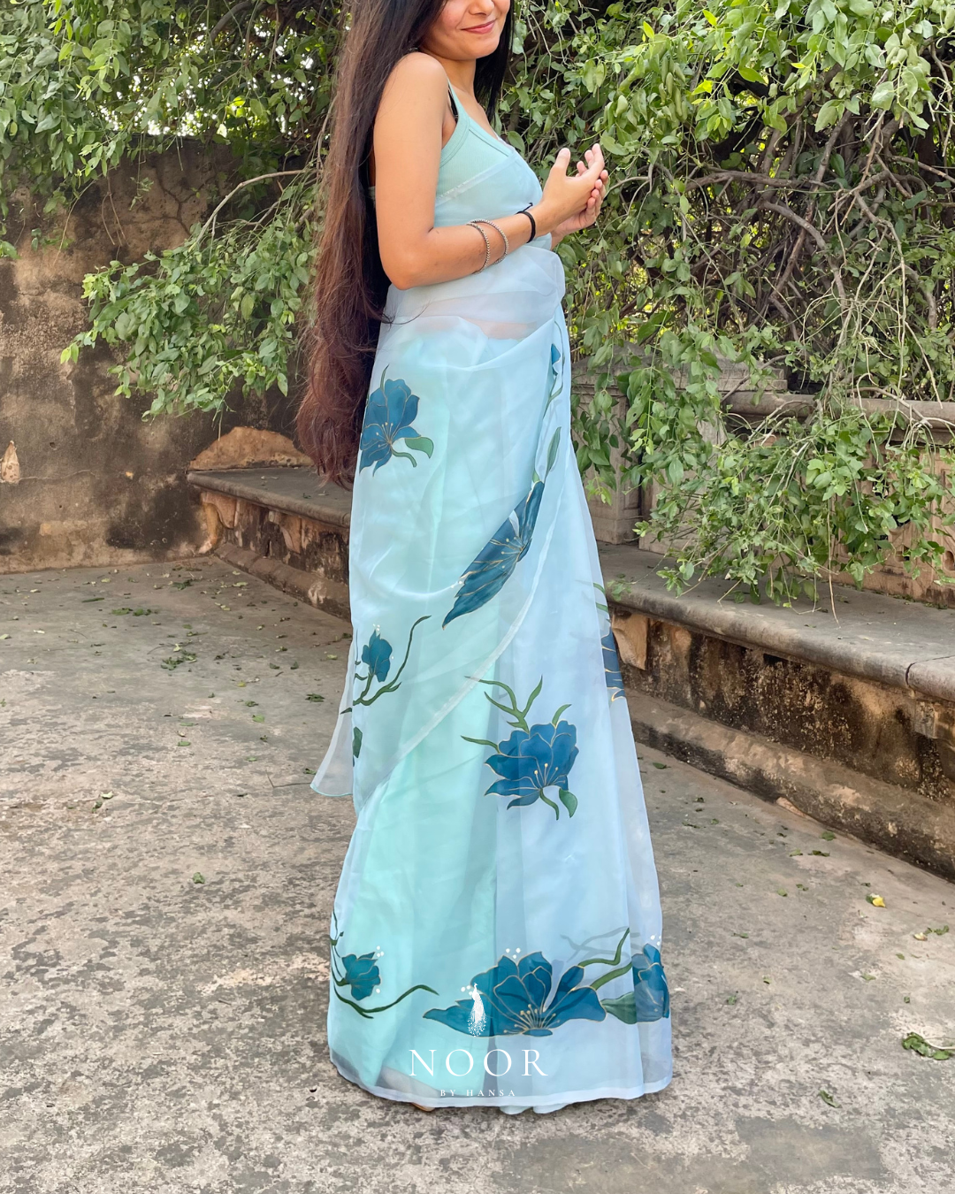 hand painted saree in pure organza silk by noor by hansa in teal colour paired with a pure cotton blouse piece, shells on the pallu