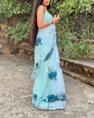 hand painted saree in pure organza silk by noor by hansa in teal colour paired with a pure cotton blouse piece, shells on the pallu