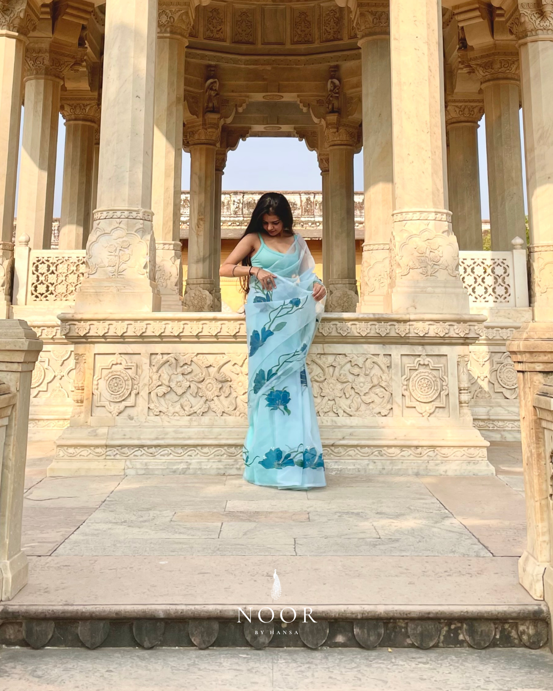 hand painted saree in pure organza silk by noor by hansa in teal colour paired with a pure cotton blouse piece, shells on the pallu