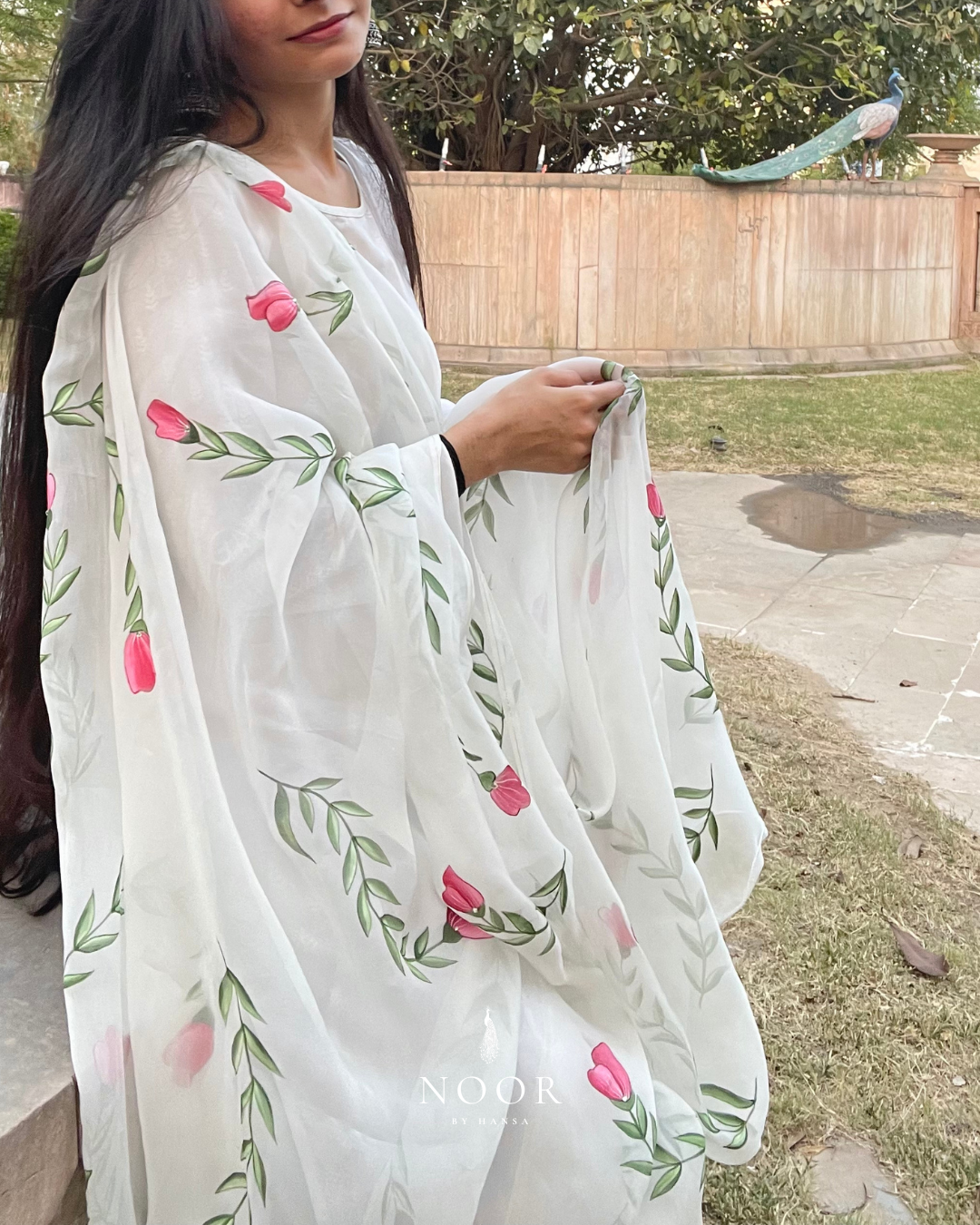 hand painted ivory 'jaituni' odhani in pure organza silk fabric with hand-painted motifs of leaves &amp; pink tulips spread all over, embellished with studded stones. light and flowy, this makes for a perfect summer essential