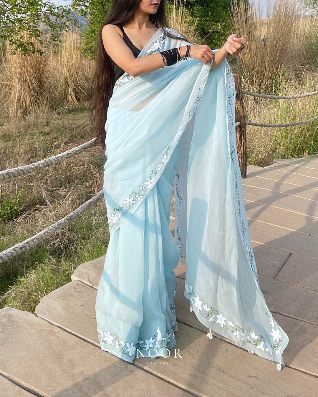 hand painted saree in pure organza silk by noor by hansa in blue colour paired with a pure cotton blouse piece, shells on the pallu